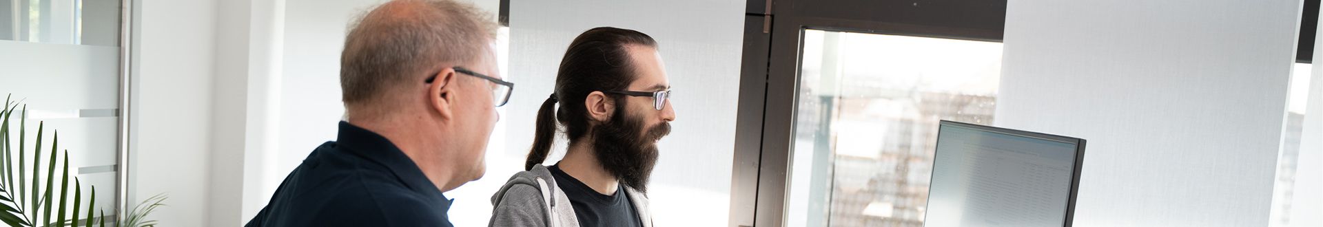 Two esatus specialists discussing KYC integration at a workstation